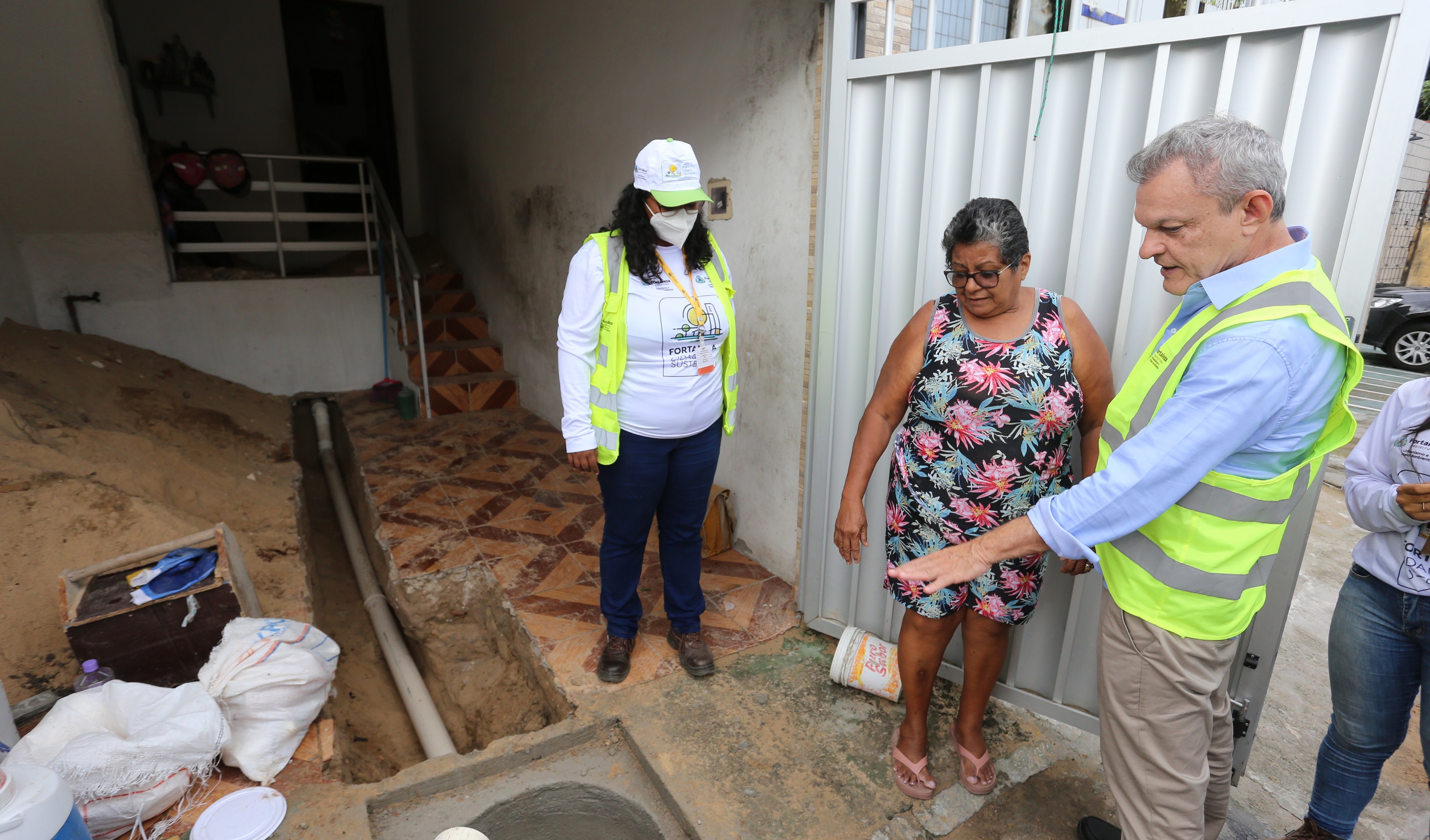 sarto conversa com uma moradora na frente da casa dela onde ocorre uma obra